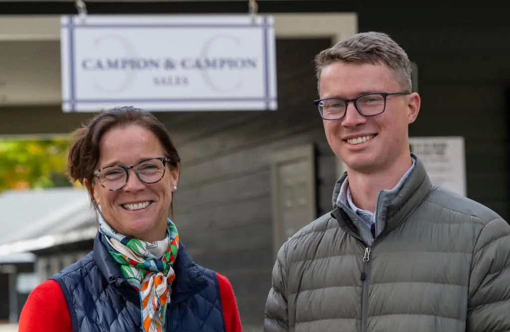 Lesley and Paddy Campion smiling in front of the Campion & Campion sign